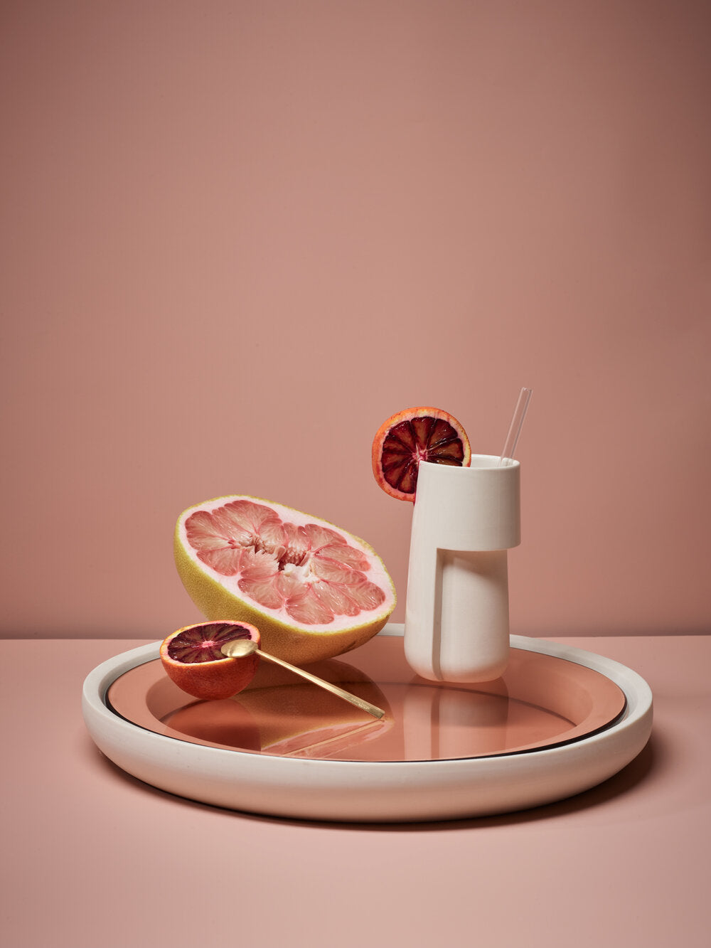 Hiball ceramic cup sits atop a glass tray with sliced blood orange