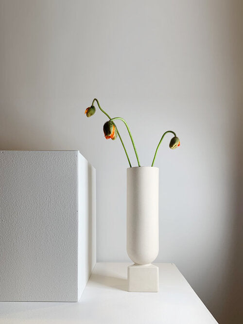 Tall matte white porcelain vase with glazed triangular base